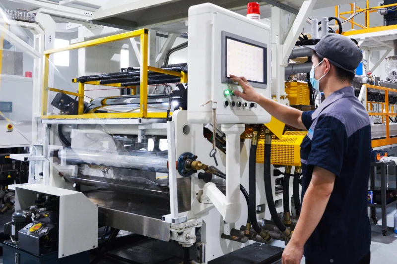 DESU Plastic production operator controlling plastic sheet extrusion equipment